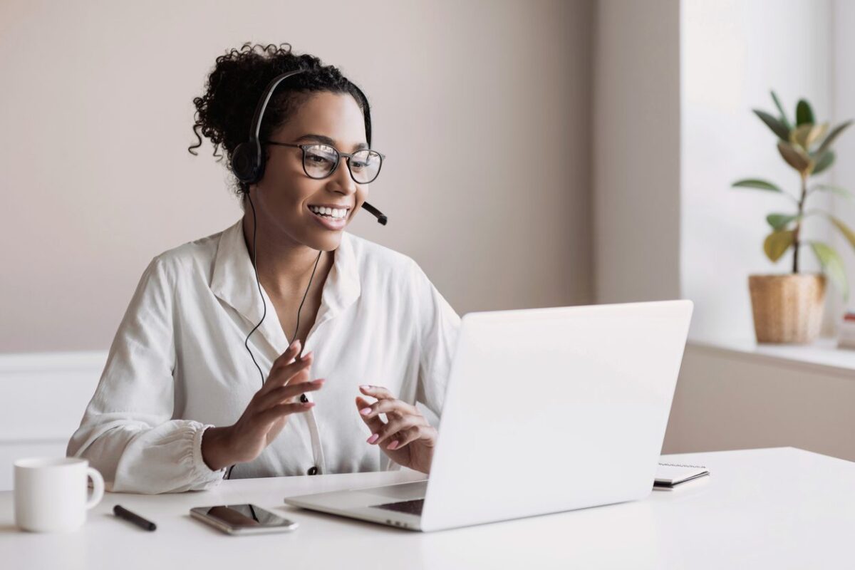 Woman working with speech recognition on her computer. She has a headset on.