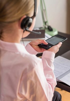 a woman wearing headphones and holding a phone