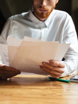 a man holding papers on a table