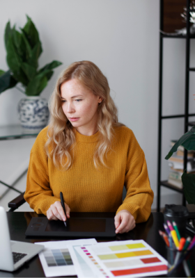 a woman sitting at a desk using a tablet, she is using Enfocus Switch