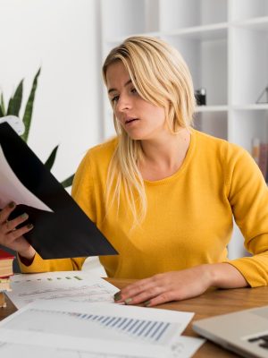 a woman sitting at a desk reading a document