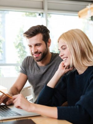 a man and woman looking at a laptop