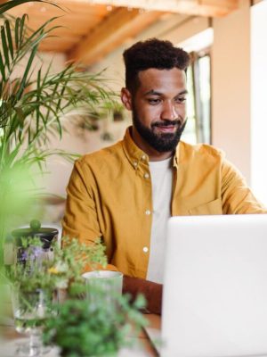 A young man with laptop and coffee working