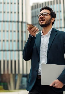 Businessman recording audio message to client standing near office during break