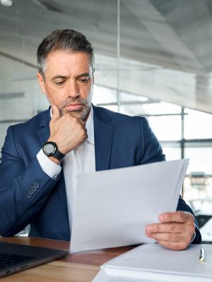 a man in a suit looking at a piece of paper