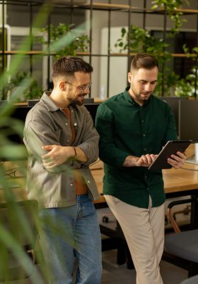 Two professionals are engaged in a focused conversation while holding digital tablet