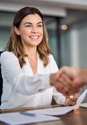 Happy mid aged business woman manager handshaking at office meeting. a woman shaking hands with a man