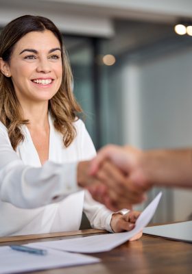 Happy mid aged business woman manager handshaking at office meeting. Happy mid aged business woman manager handshaking at office meeting.
