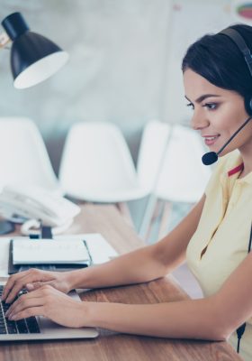 Zakenvrouw praat met headset op en zet gegevens in haar computer