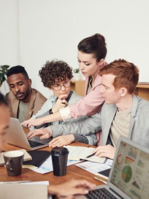 Een team mensen dat samenwerkt aan een laptop