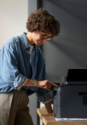 a woman standing in front of a printer