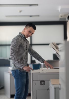 young business man copy documents on copy machine at modern startup office interior, casual clothes